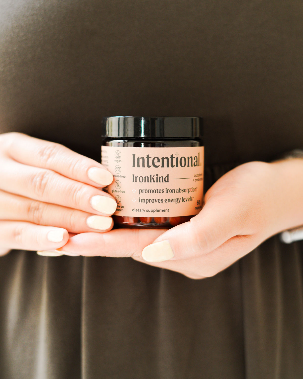 Vegan lactoferrin and prebiotic supplement IronKind Intentional held by  woman